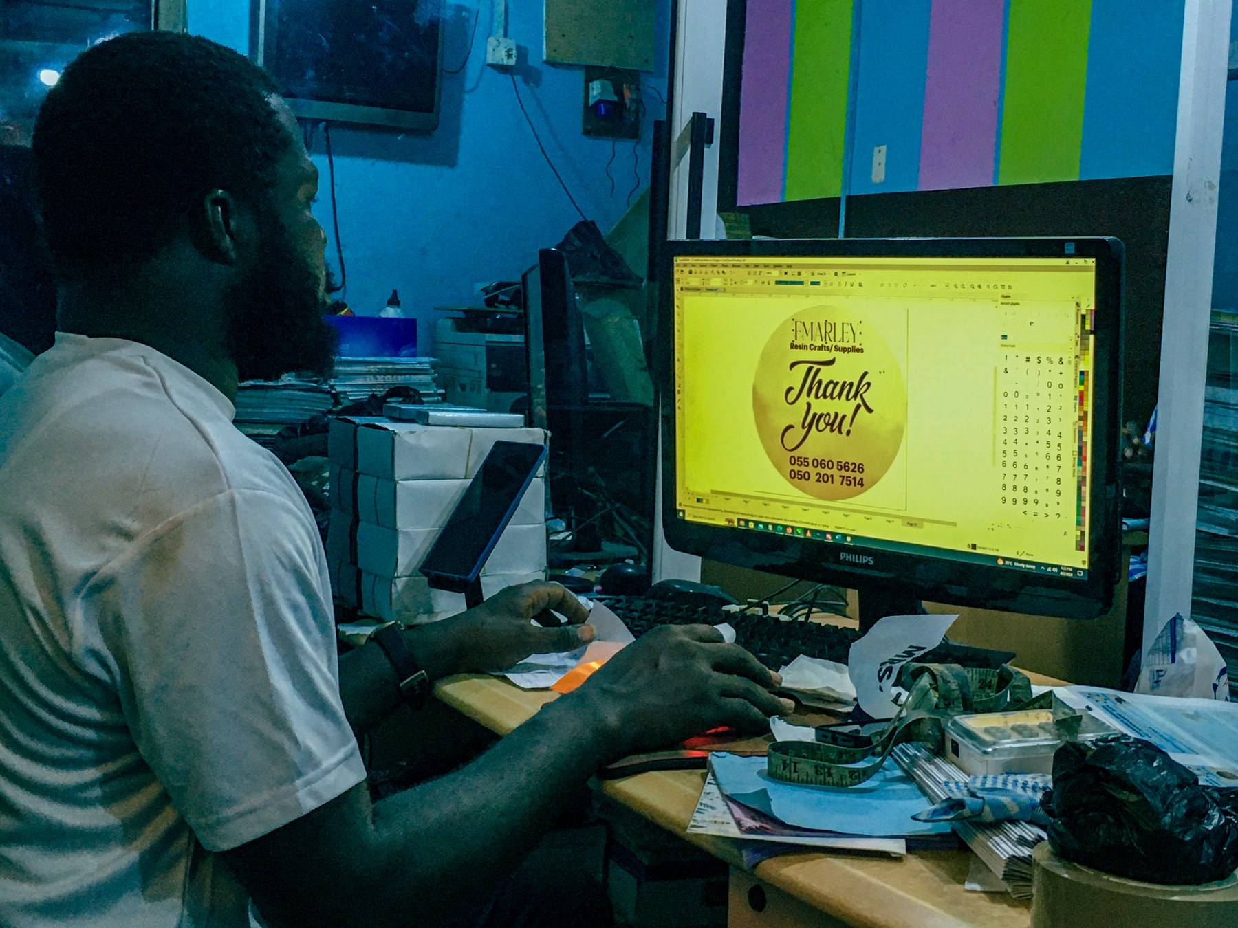 designer travaillant sur un visuel client affiché à l'écran, dans son espace de travail